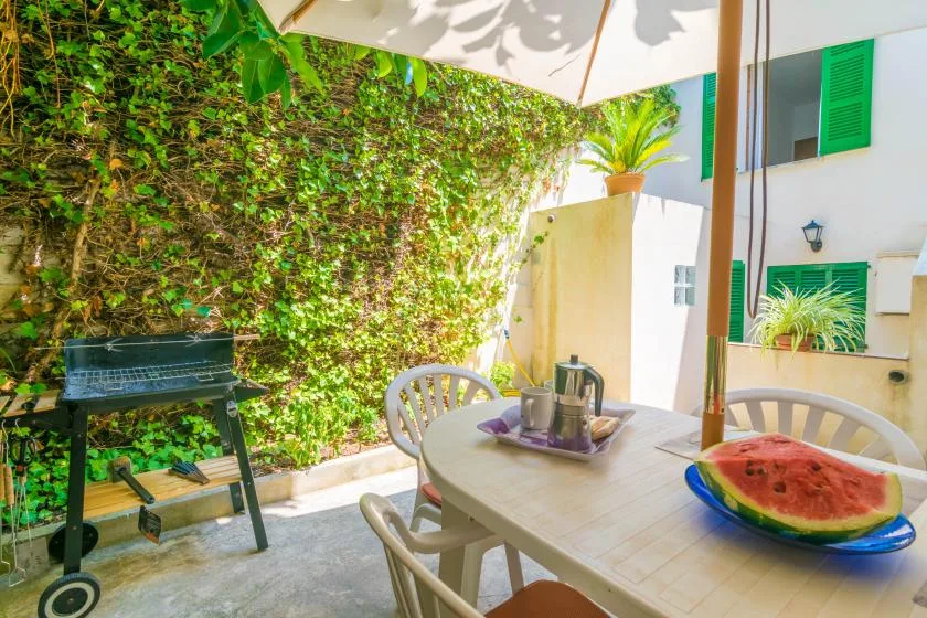 An outdoor dining patio with a table beneath a large umbrella.