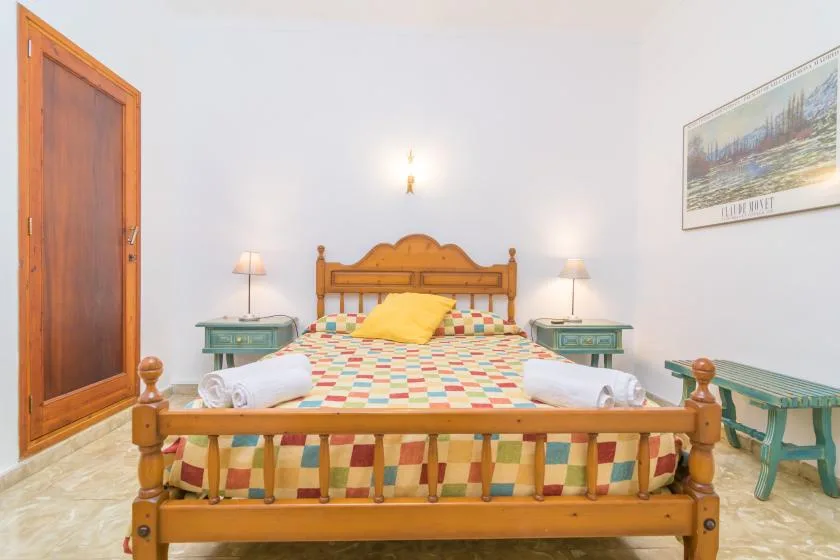 A bedroom with a wooden bed, colorful bedding, and matching bedside tables.