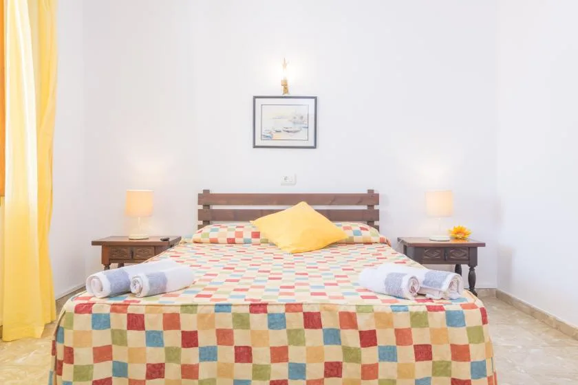 A bedroom with a neatly made bed and matching bedside tables.