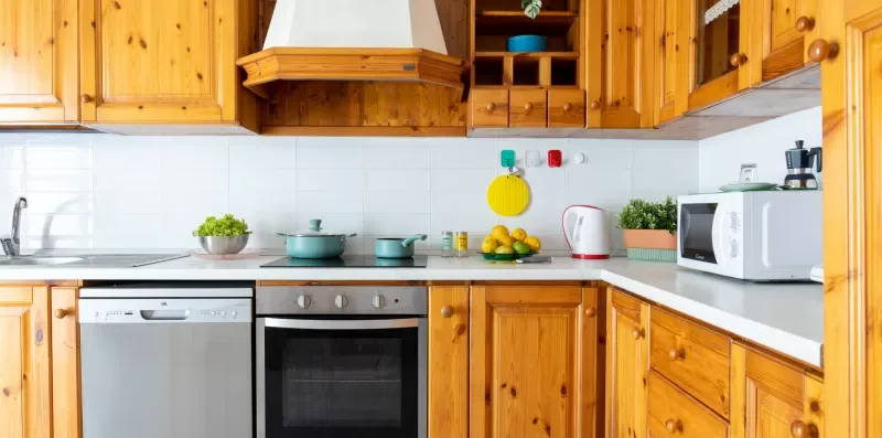 Una cocina luminosa con gabinetes de madera y una encimera.