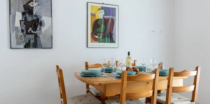 Un comedor con una mesa de madera puesta con vajilla y cristalería.