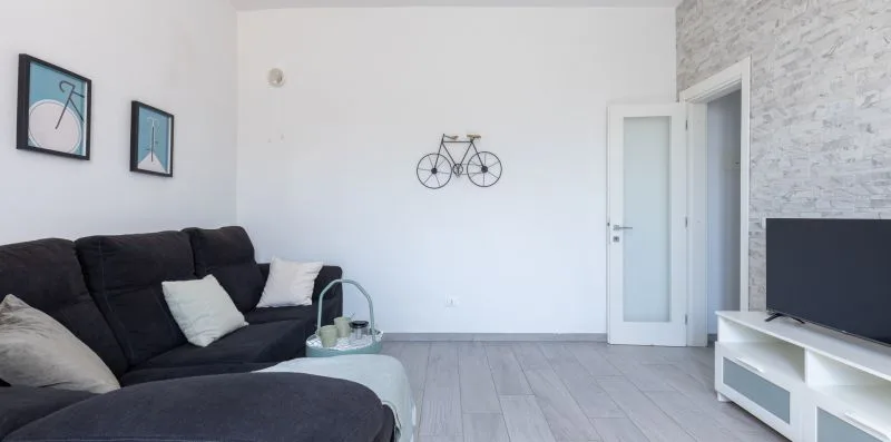 Una sala de estar con asientos oscuros, cuadros en la pared y un televisor.