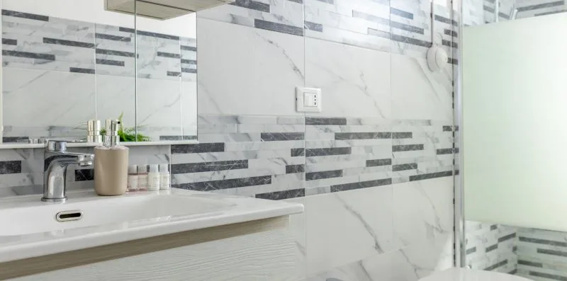 Un baño con lavabo y ducha de vidrio.