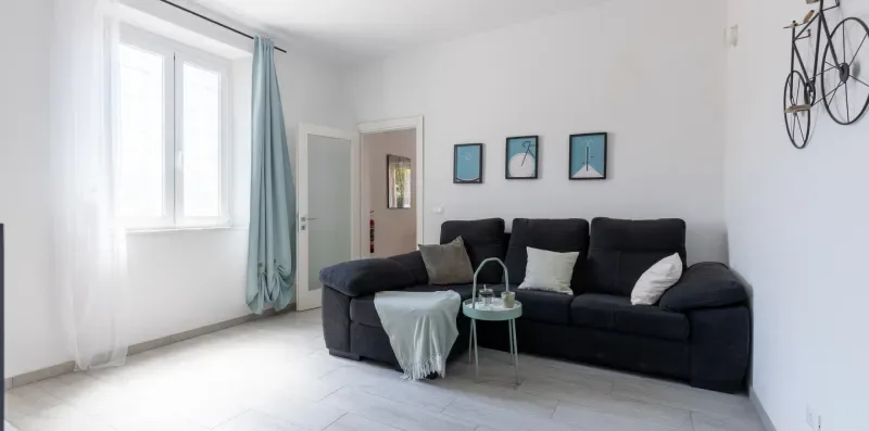 Una sala luminosa con asientos oscuros, cuadros enmarcados y una ventana grande.