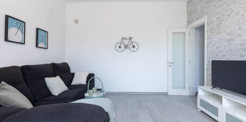 Una sala de estar con asientos oscuros, cuadros enmarcados y un televisor.