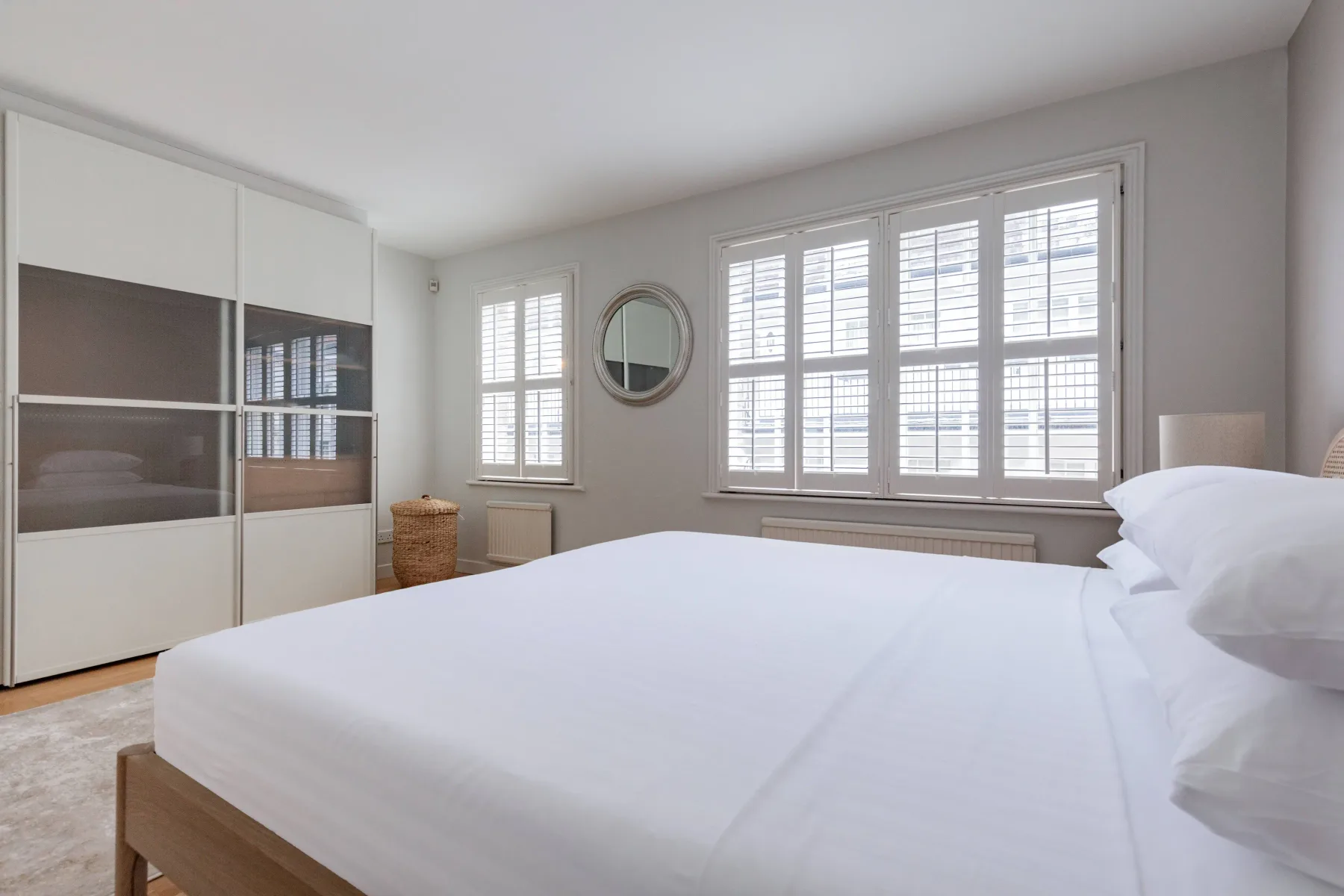 A bright bedroom with a large bed and wide windows.