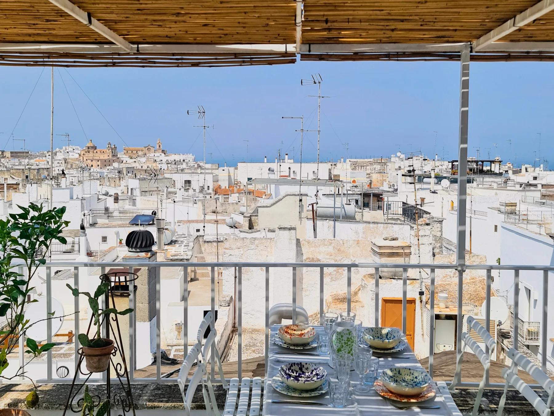 Una zona de comedor en la azotea ofrece vistas de un paisaje urbano bajo un techo de madera.