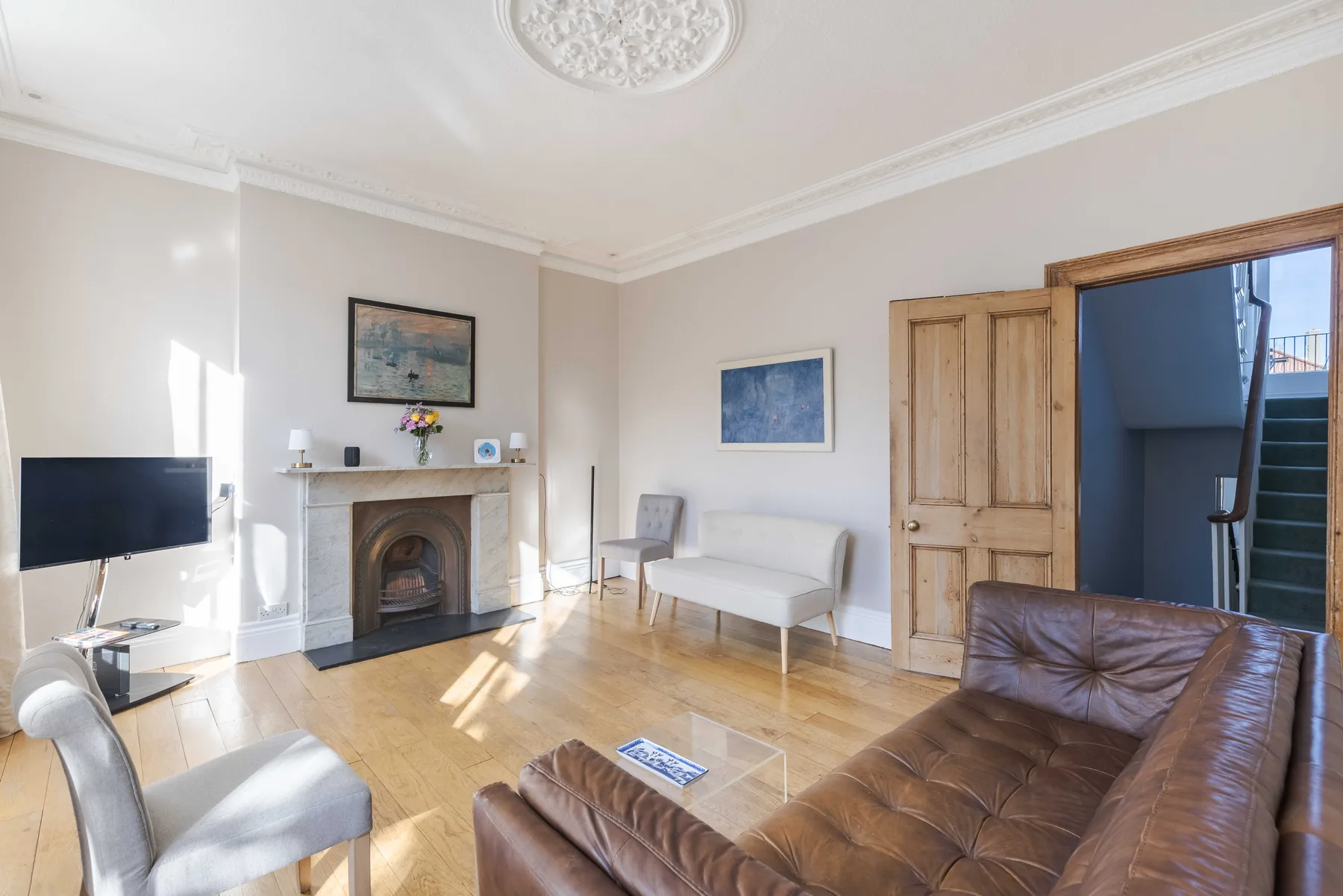 A bright living room with a fireplace, seating, and a television.
