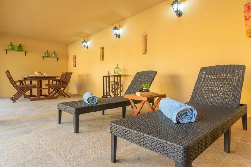 A furnished patio with woven lounge seating, a small table, and a dining set.