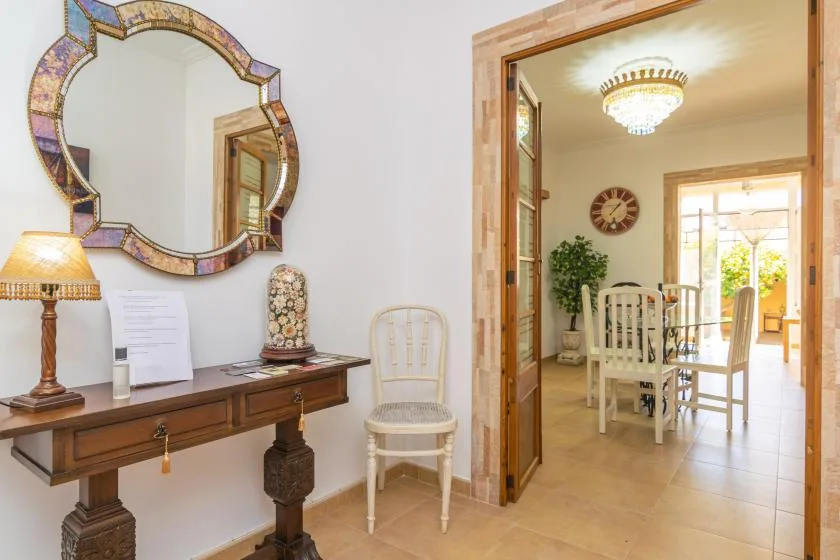 A console table and mirror sit beside an open doorway to a dining area.