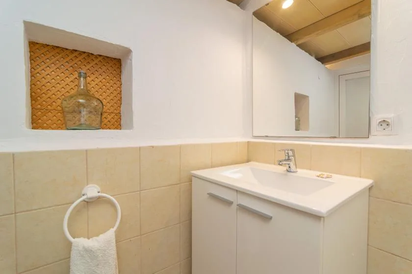 A bathroom vanity with a sink sits beneath a large wall mirror.