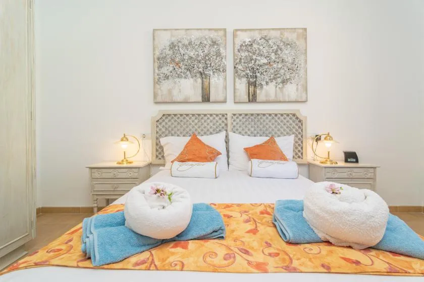 A bedroom with two beds, bedside tables, and framed artwork above the headboards.