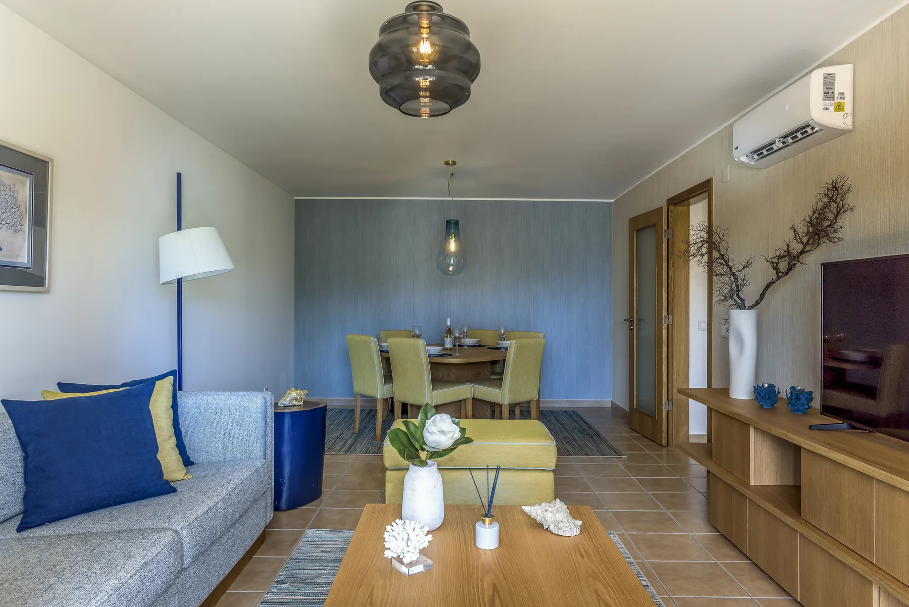 Una zona de estar y comedor con asientos, una mesa y un televisor.