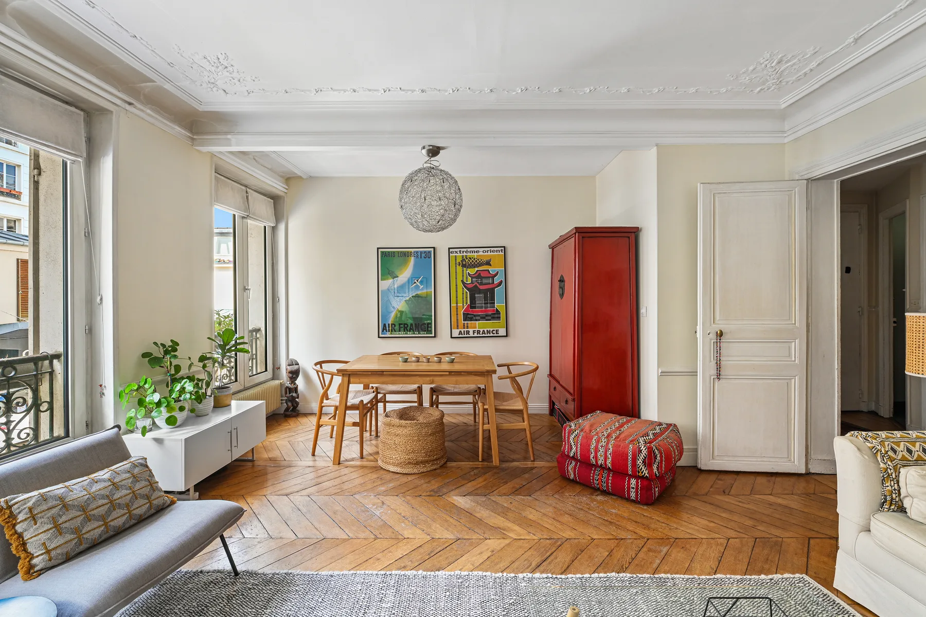 Una luminosa sala de estar y comedor con una mesa de madera y grandes ventanas.