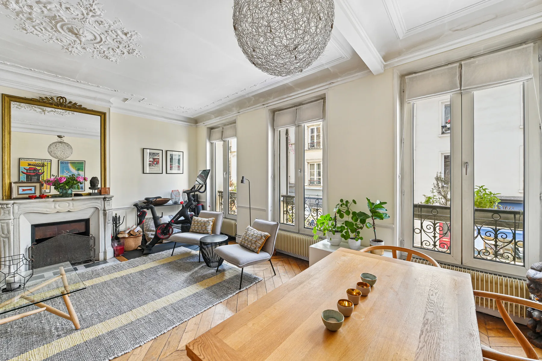 A bright living room with a fireplace, seating, and large windows.