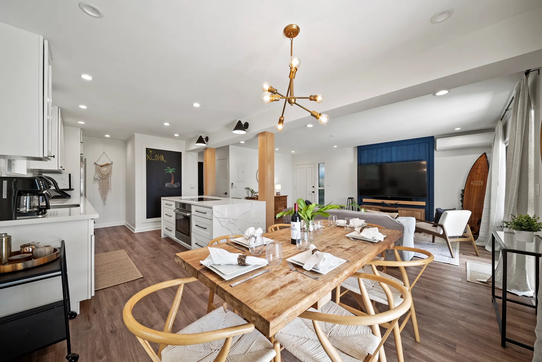 Una luminosa cocina y comedor de planta abierta con una mesa de madera e isla.