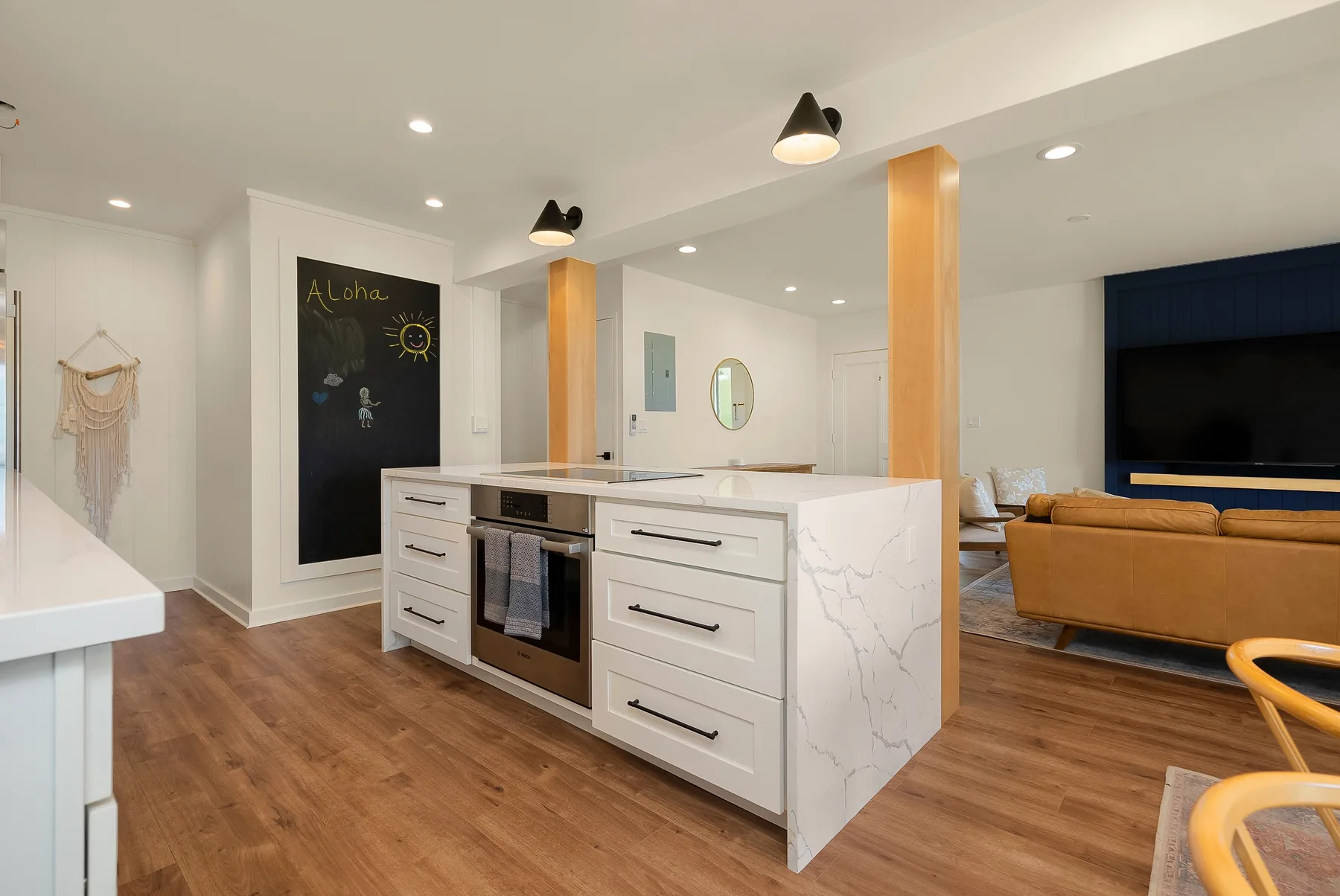 Una cocina luminosa y sala de estar de concepto abierto con una isla central y asientos.