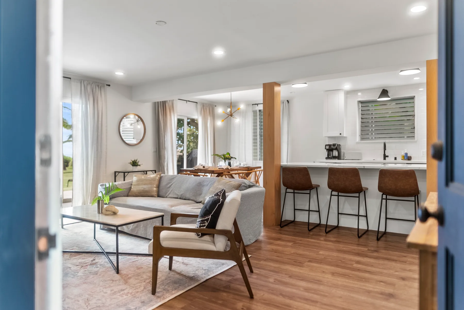 Una sala de estar y cocina de concepto abierto, con una barra y asientos altos.