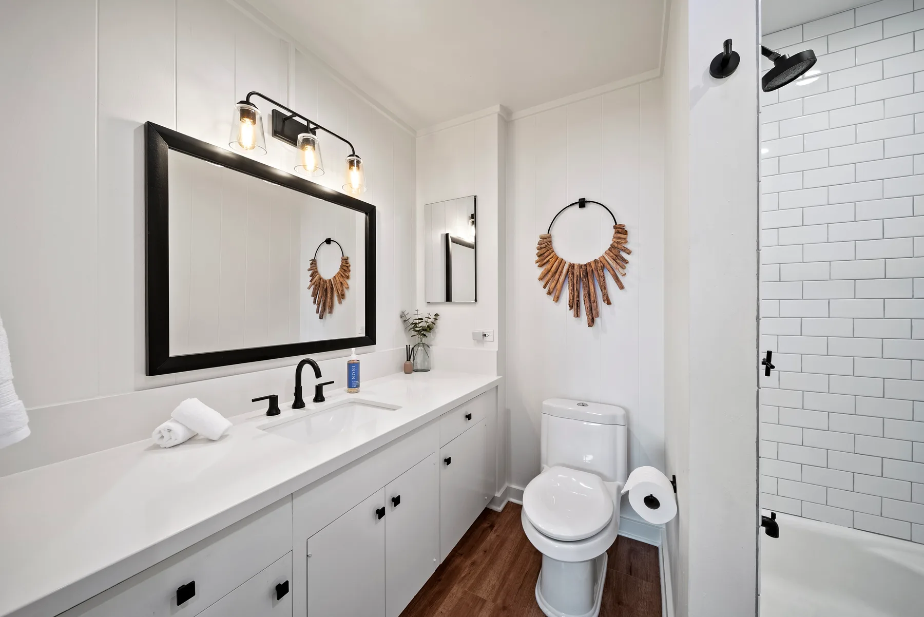 Un baño luminoso con un tocador largo y una ducha alicatada.