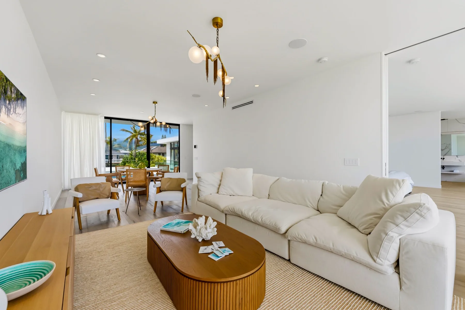 A bright living room with a large sectional seating area and dining table.