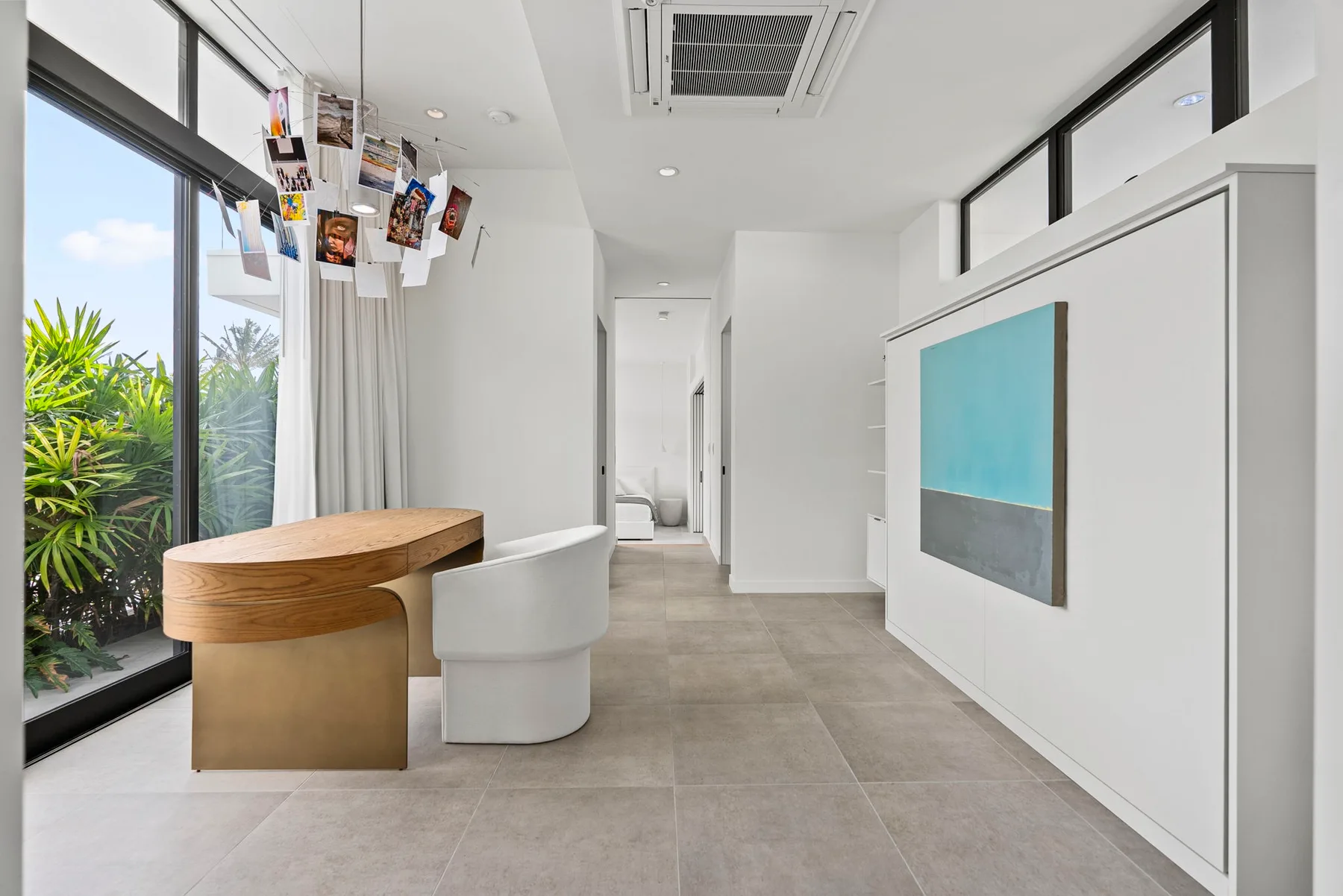 A bright modern hallway with a curved reception desk and wall-mounted artwork.