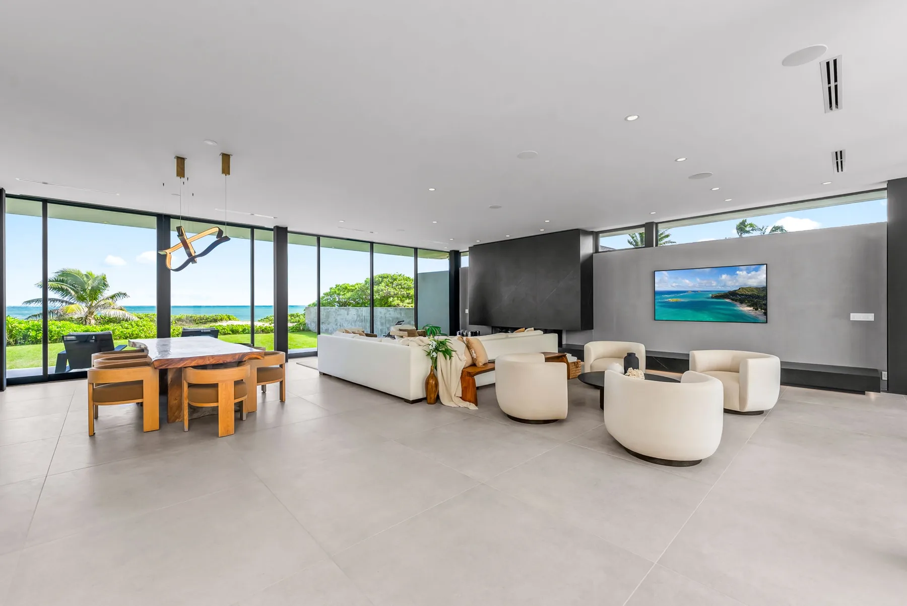 A bright open-plan living and dining area has large windows overlooking the ocean.