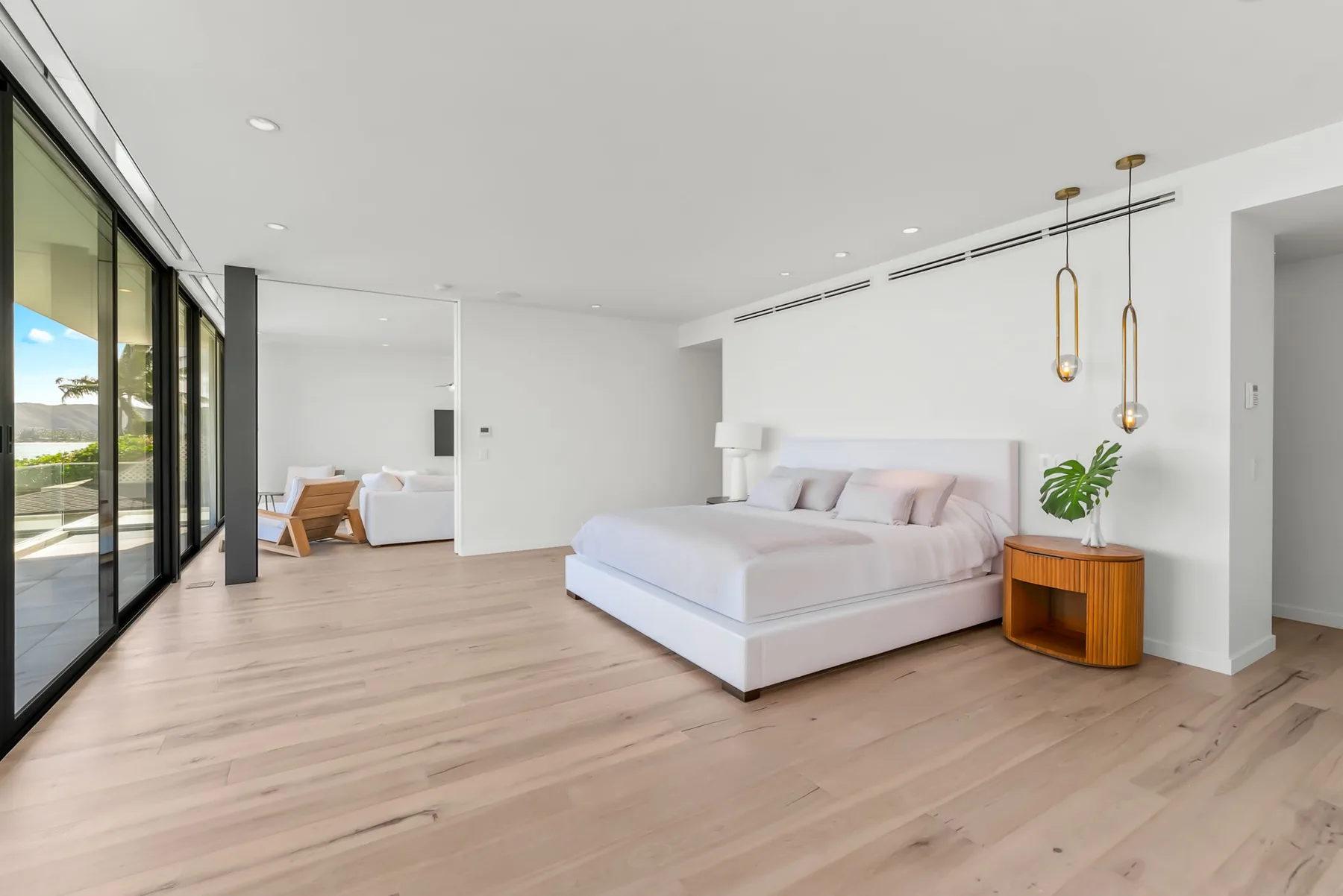 A bright bedroom with a large bed and sliding glass doors.