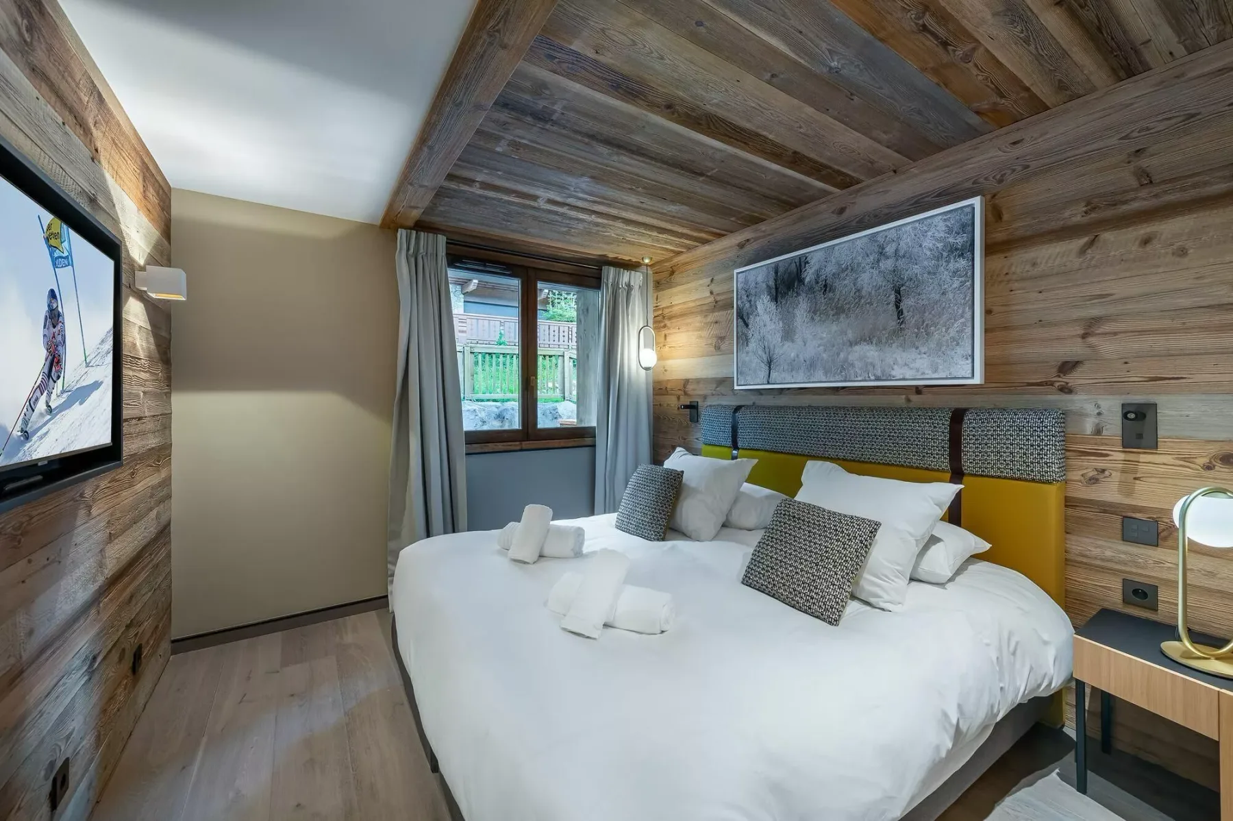 A bedroom with a large bed, bedside tables, and a window.