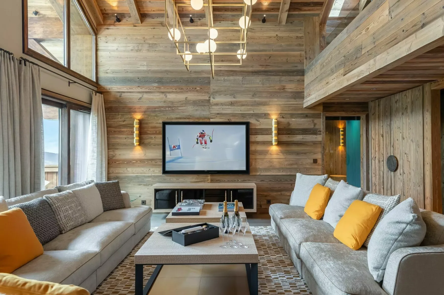 A wood-paneled living room has seating facing a television and coffee table.