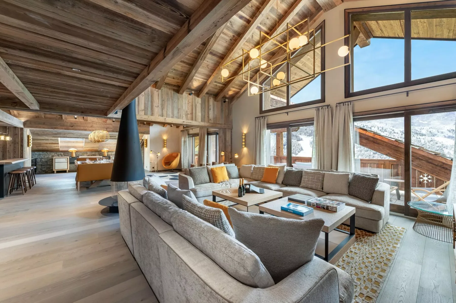 A spacious living room with sectional seating, a coffee table, and large windows.