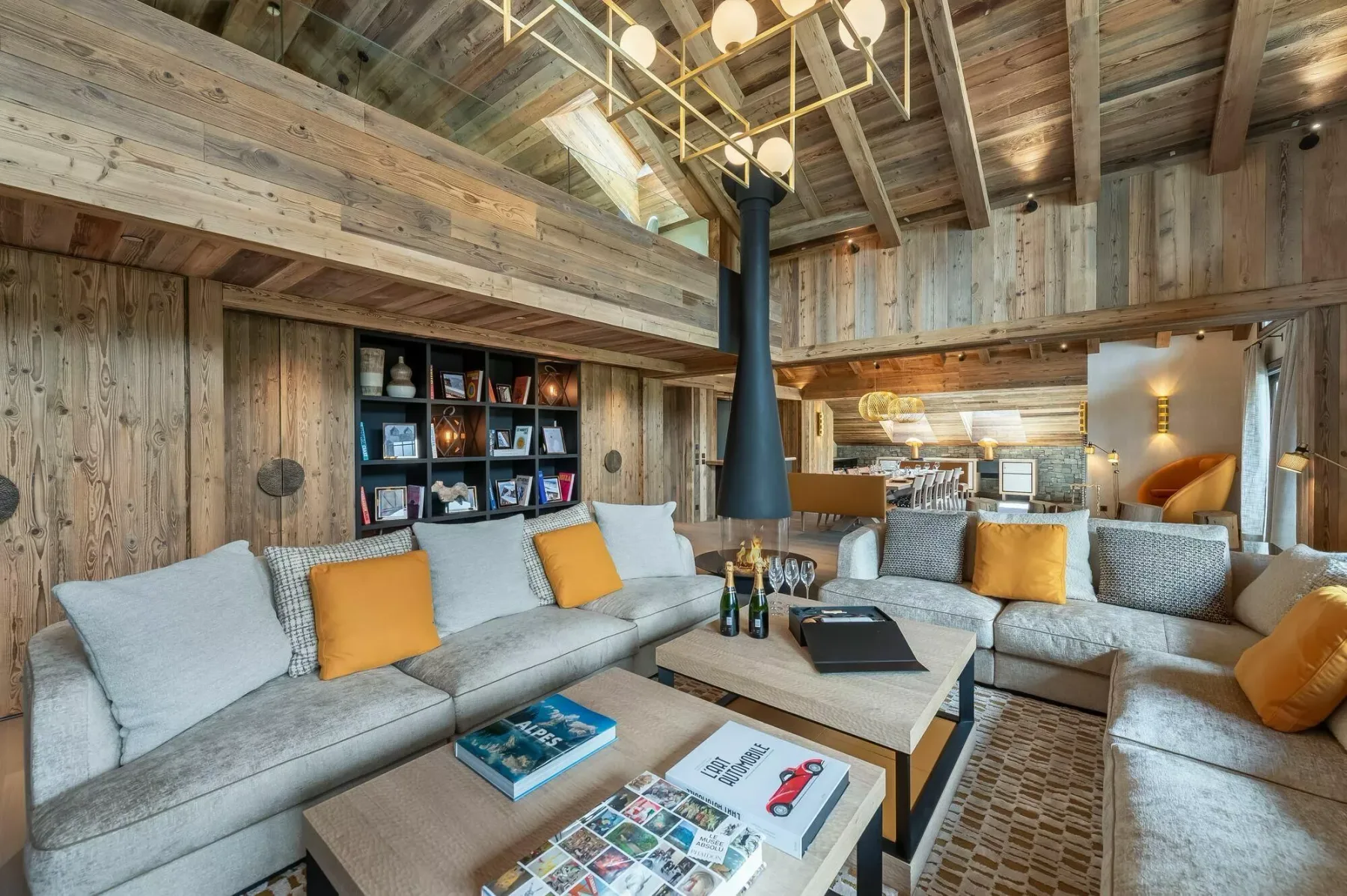 A spacious living room with seating, coffee tables, and exposed timber beams.