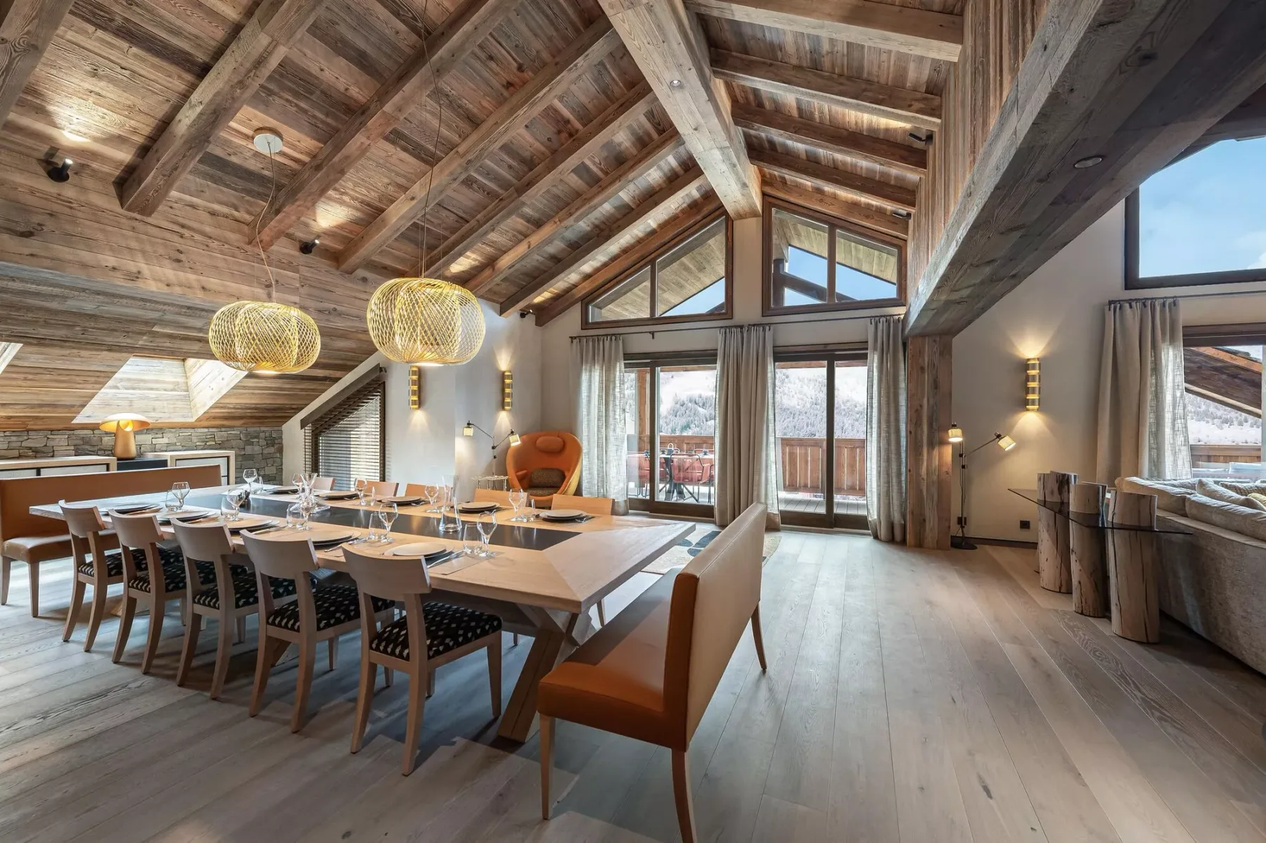 A spacious dining area features a long table beneath exposed timber beams.