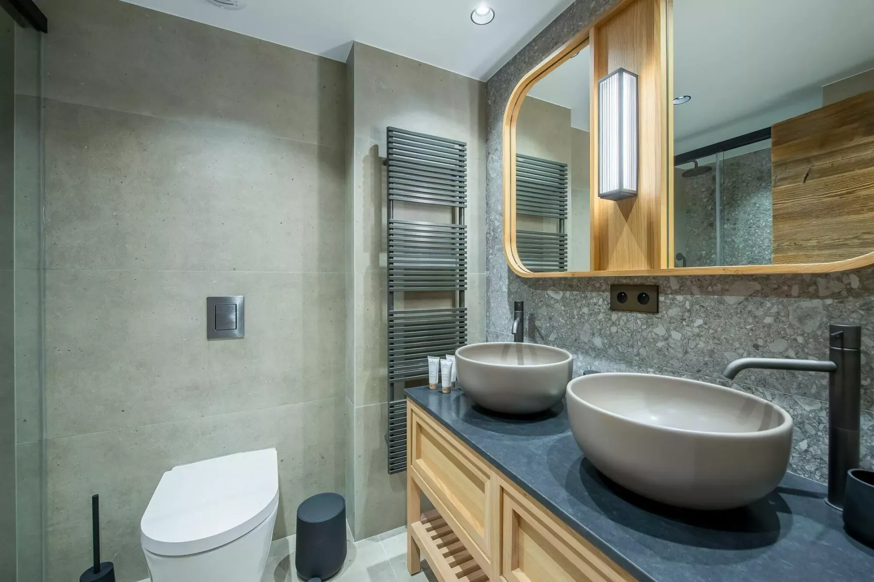 A modern bathroom with a double vanity, vessel sinks, and a large mirror.