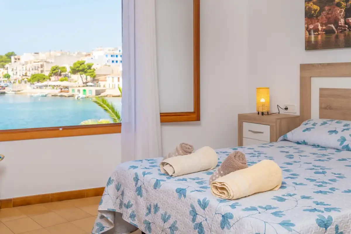 Un dormitorio con una cama junto a una ventana con vistas al agua.