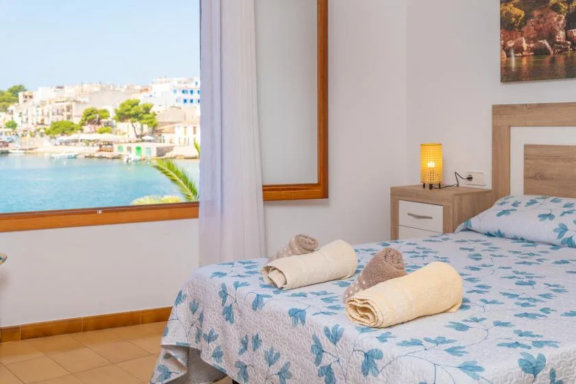 Un dormitorio con una cama junto a una ventana con vistas al paseo marítimo.