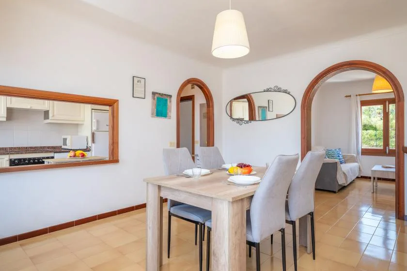 Comedor con una mesa y sillas junto a puertas arqueadas.