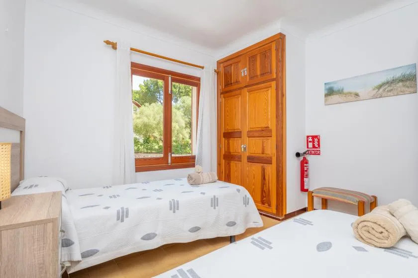 Un dormitorio con camas junto a una ventana y una puerta de madera.