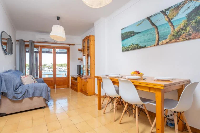 Una luminosa sala de estar y comedor con una mesa junto a una gran puerta de cristal.