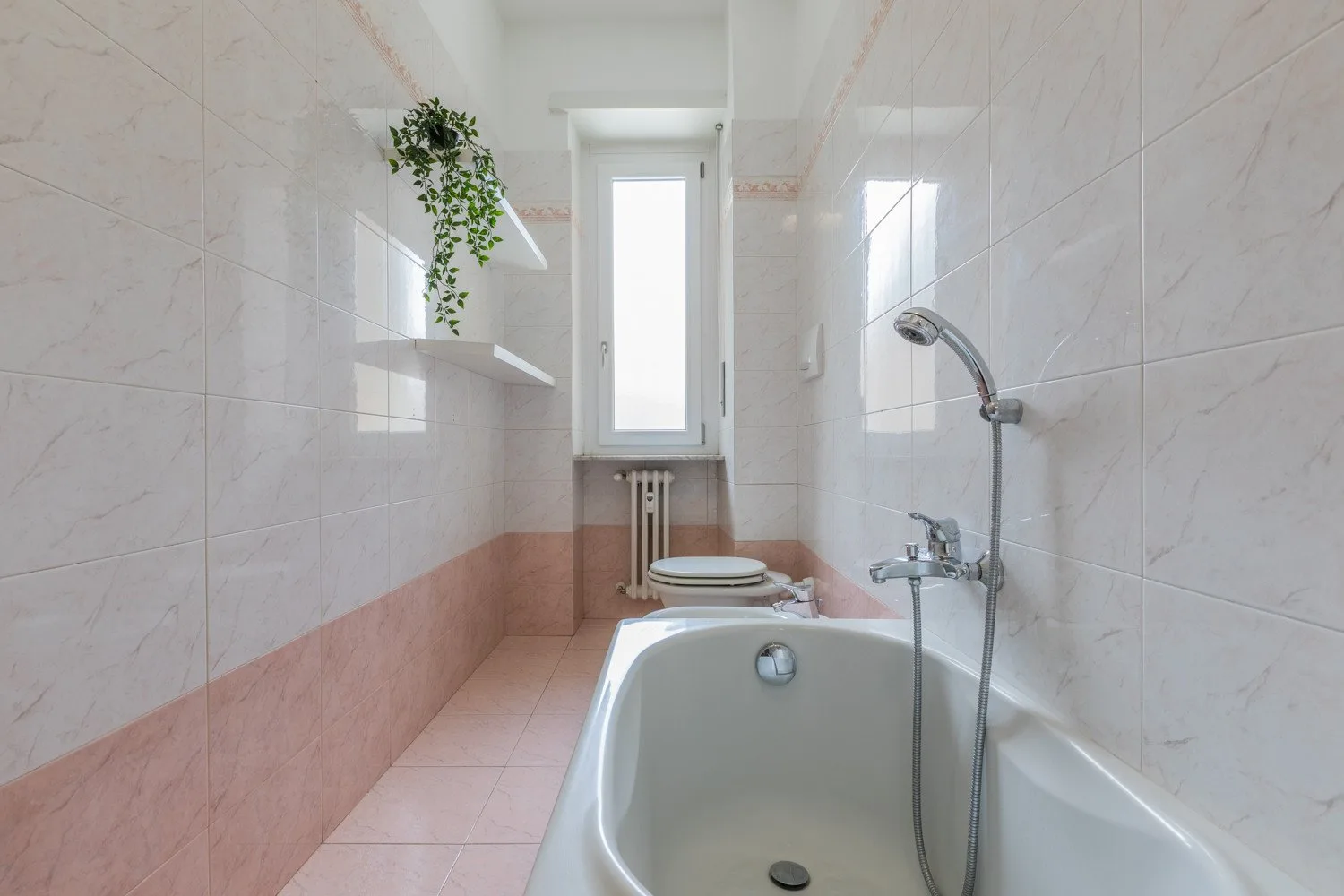 Un baño alicatado con bañera y ducha.