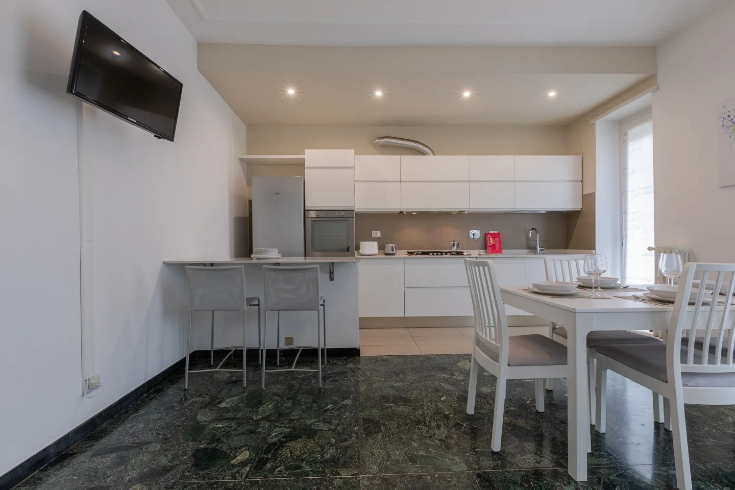Una cocina abierta al comedor, con una mesa y asientos.