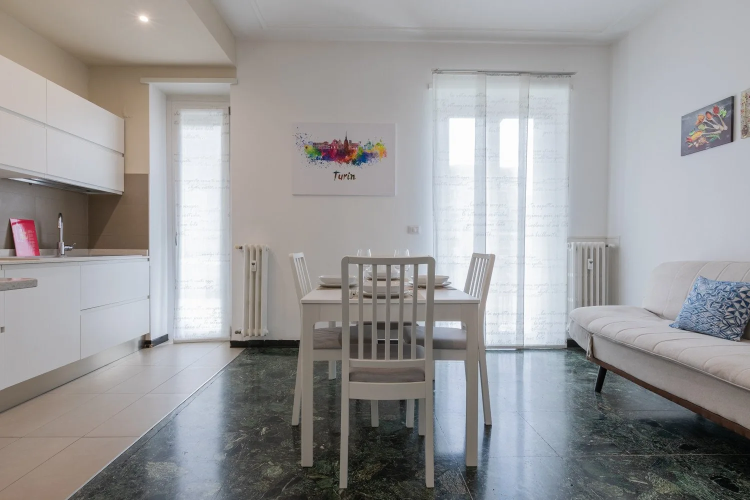 Un comedor luminoso con una mesa junto a la cocina y una ventana grande.