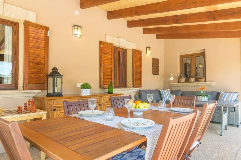 Comedor con una mesa larga de madera y asientos bajo vigas expuestas en el techo.