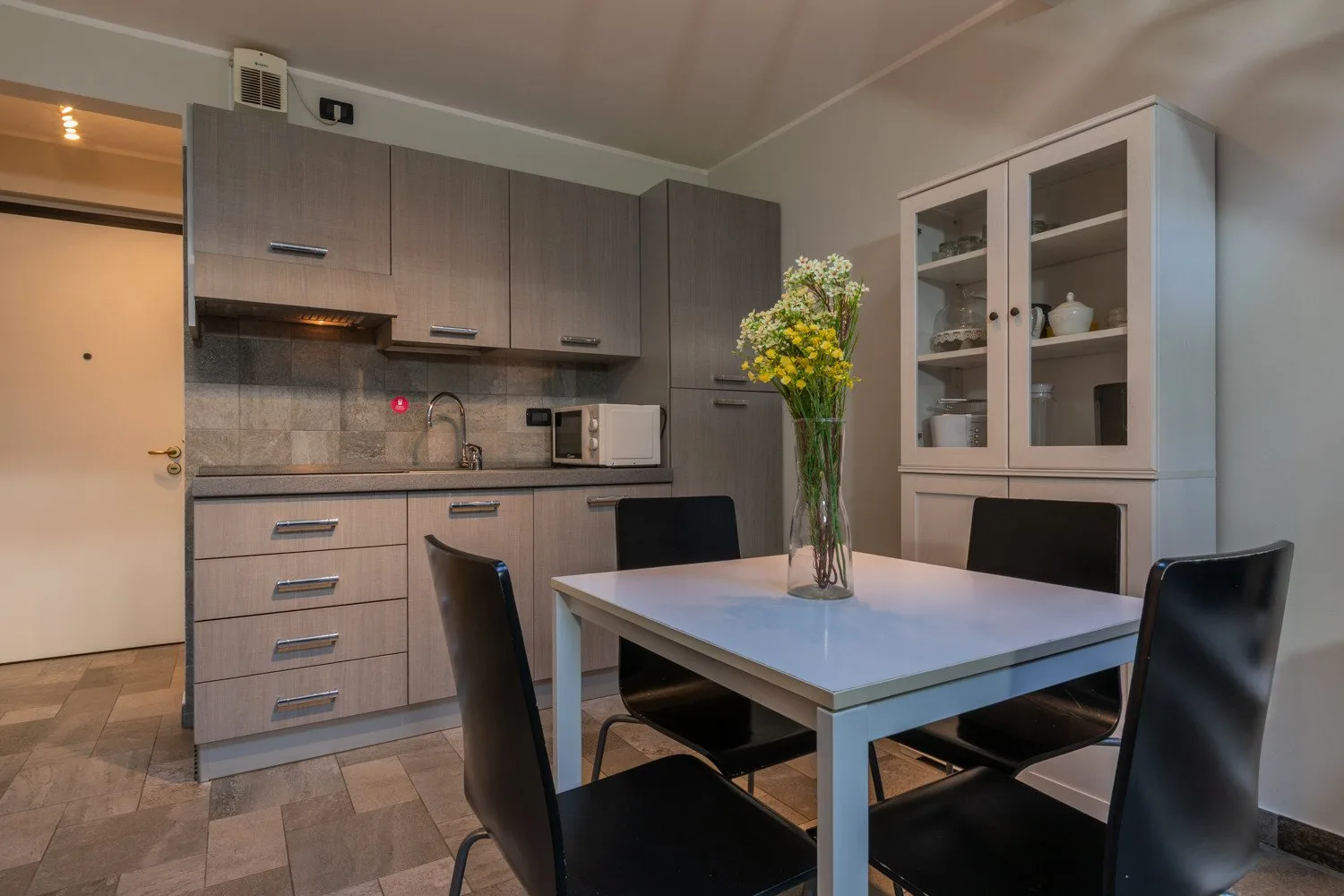 Comedor con una mesa y sillas junto a una cocina compacta.