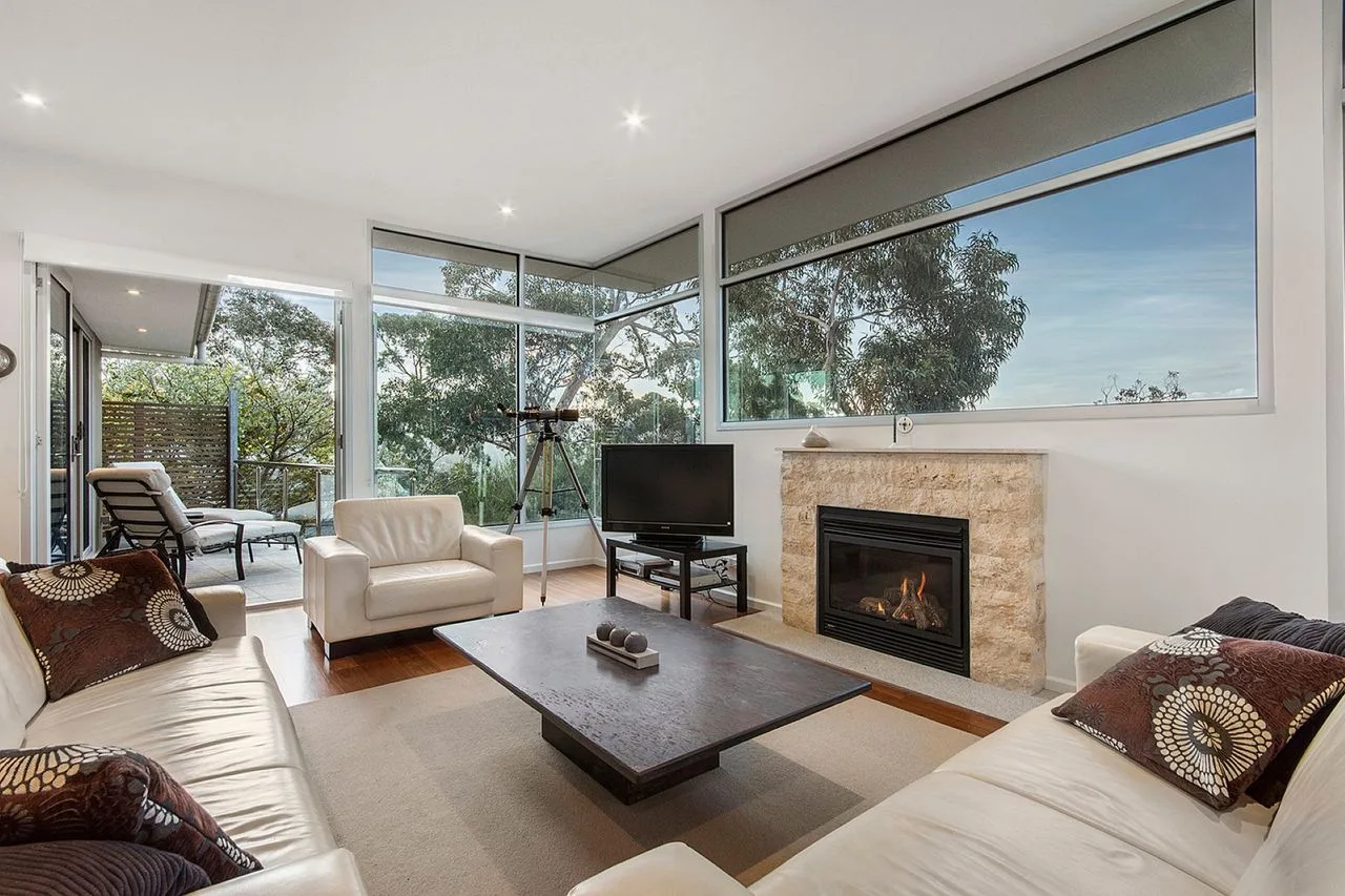 A bright living room with seating, a coffee table, and a fireplace.
