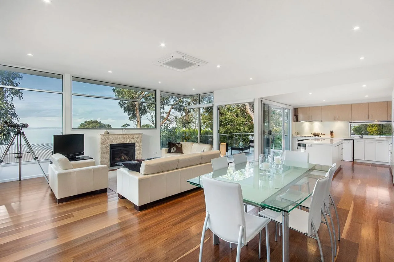 An open-plan living and dining area with large windows and a kitchen.