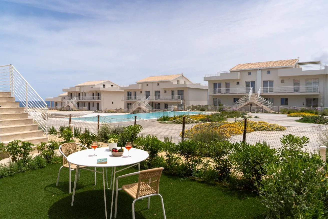 A landscaped courtyard with a pool and nearby residential buildings.