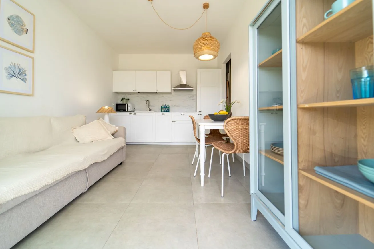 A bright living area opens onto a compact kitchen and dining table.