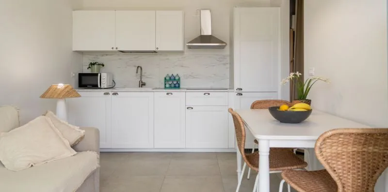 A bright kitchen and dining area with white cabinets and a table.