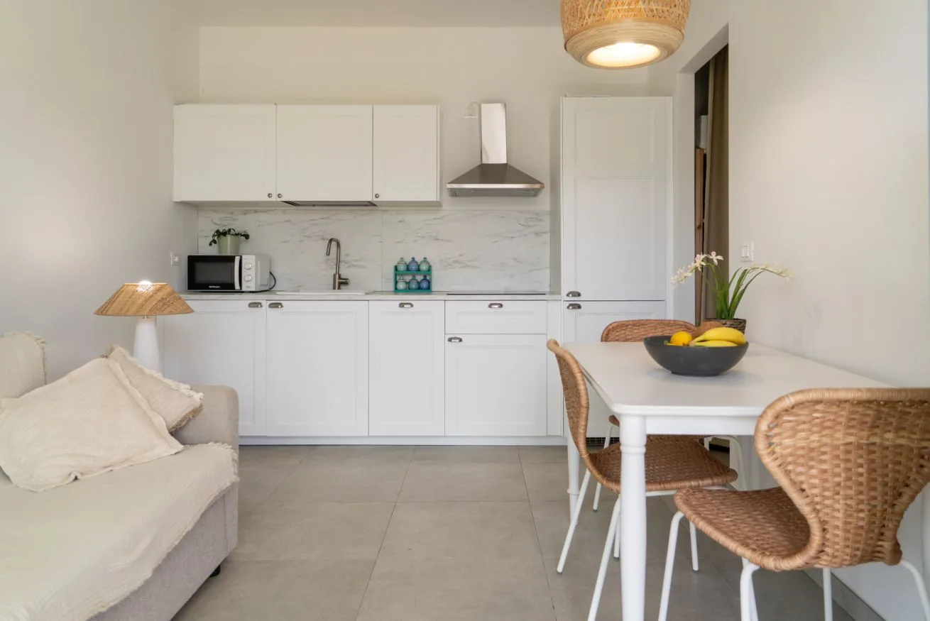 A bright kitchen and dining area with white cabinetry and a table.