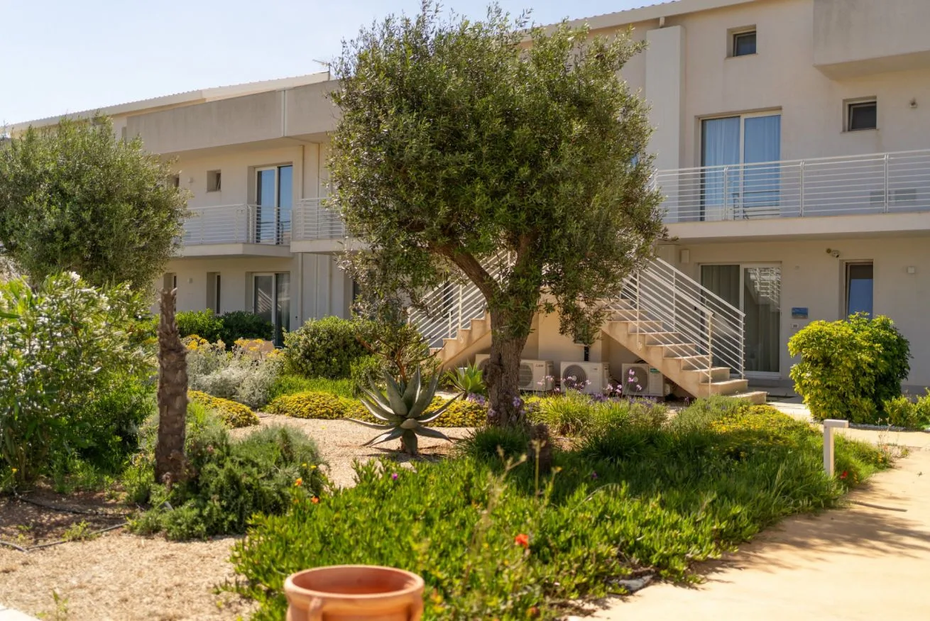 A landscaped courtyard with trees, garden paths, and an exterior staircase.